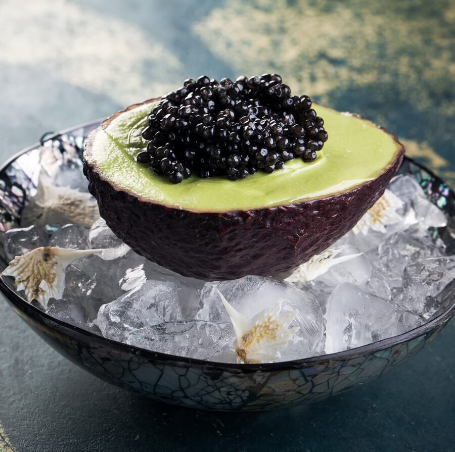 Black caviar served on avocado over ice